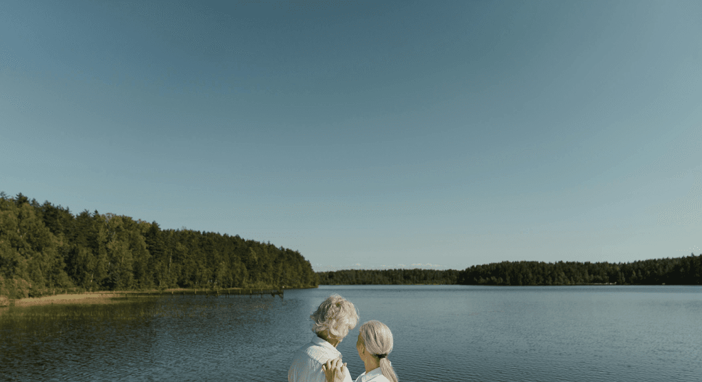 Elderly couple sitting together by a lake